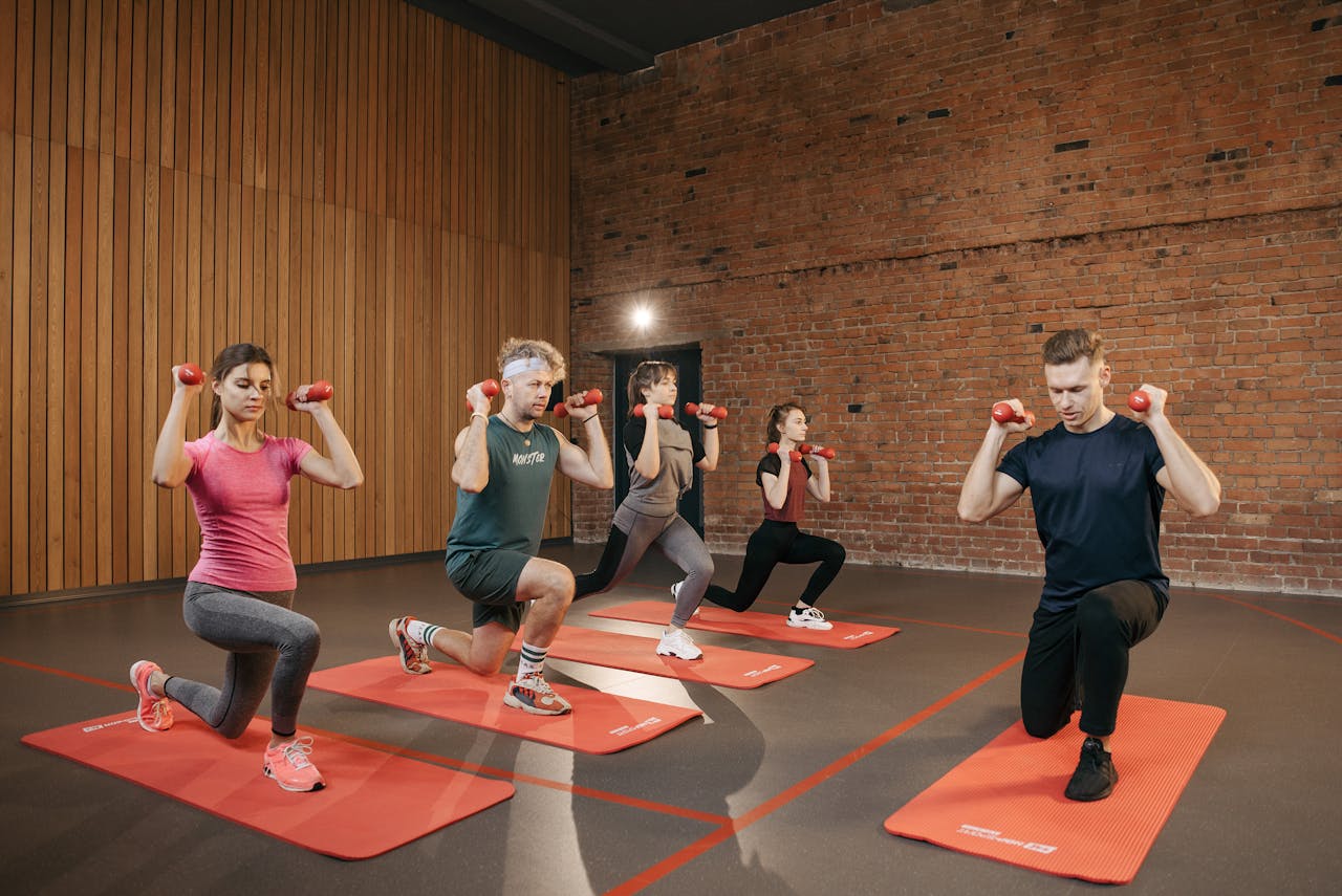 Indoor group workout session with dumbbells focusing on strength and fitness.